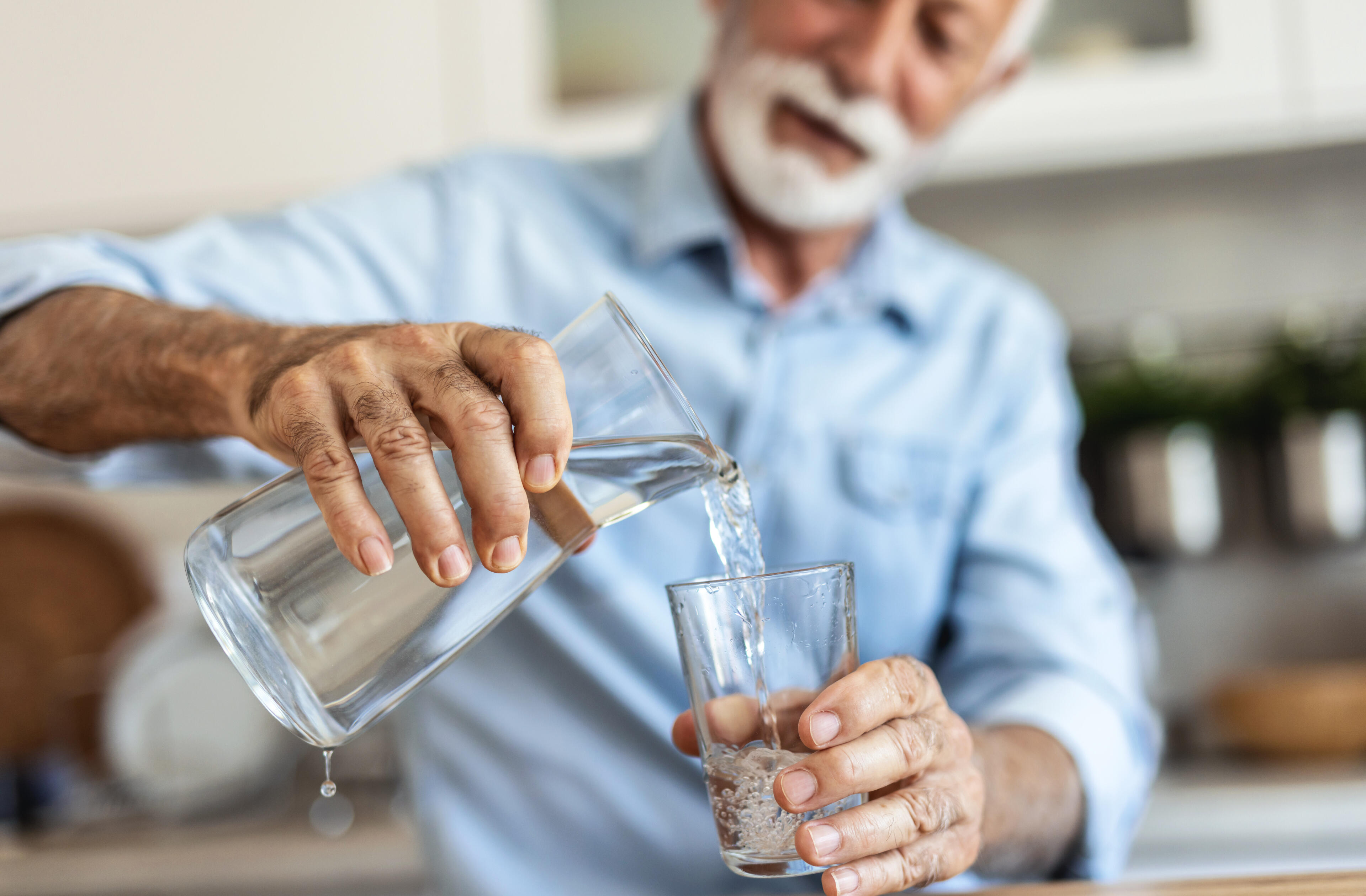drink-water-before-coffee-morning-habit Man drinking water in the morning before coffee for better hydration and energy