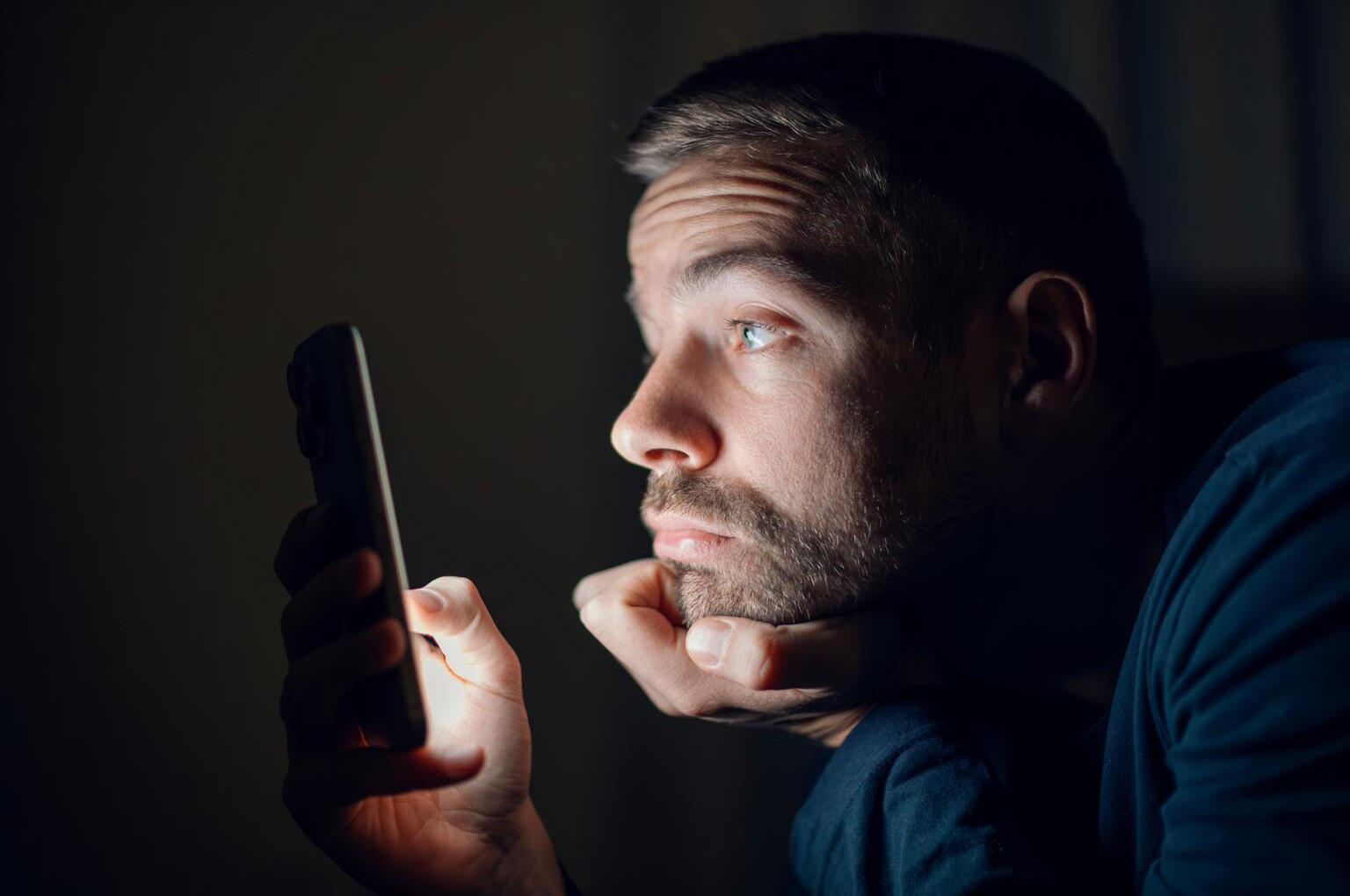 Man turning off phone at night to improve sleep quality and energy