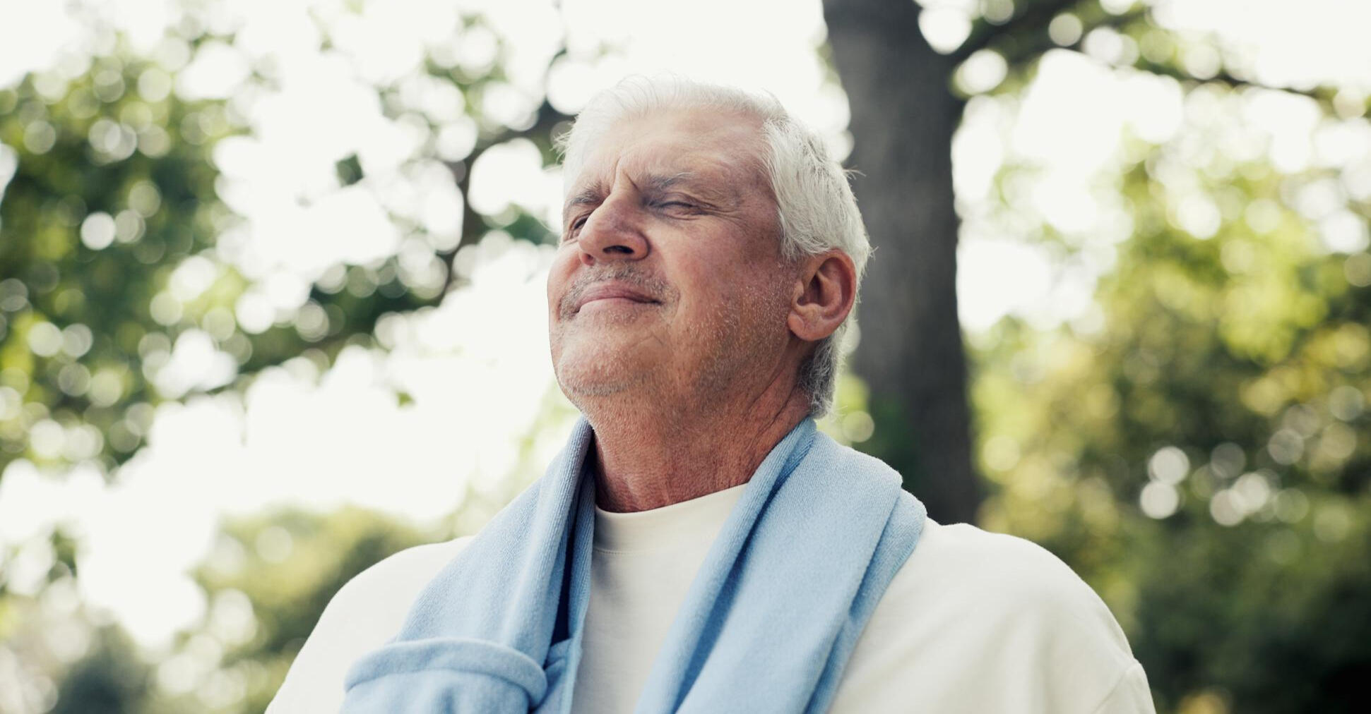 stress-relief-simple-habits-nature-walk Middle-aged man walking in nature to reduce stress and improve mood naturally